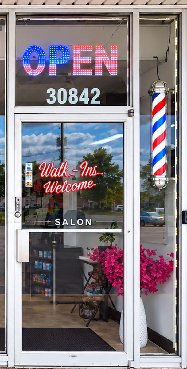 The front door with the lit OPEN sign and Walk-Ins Welcome lettering